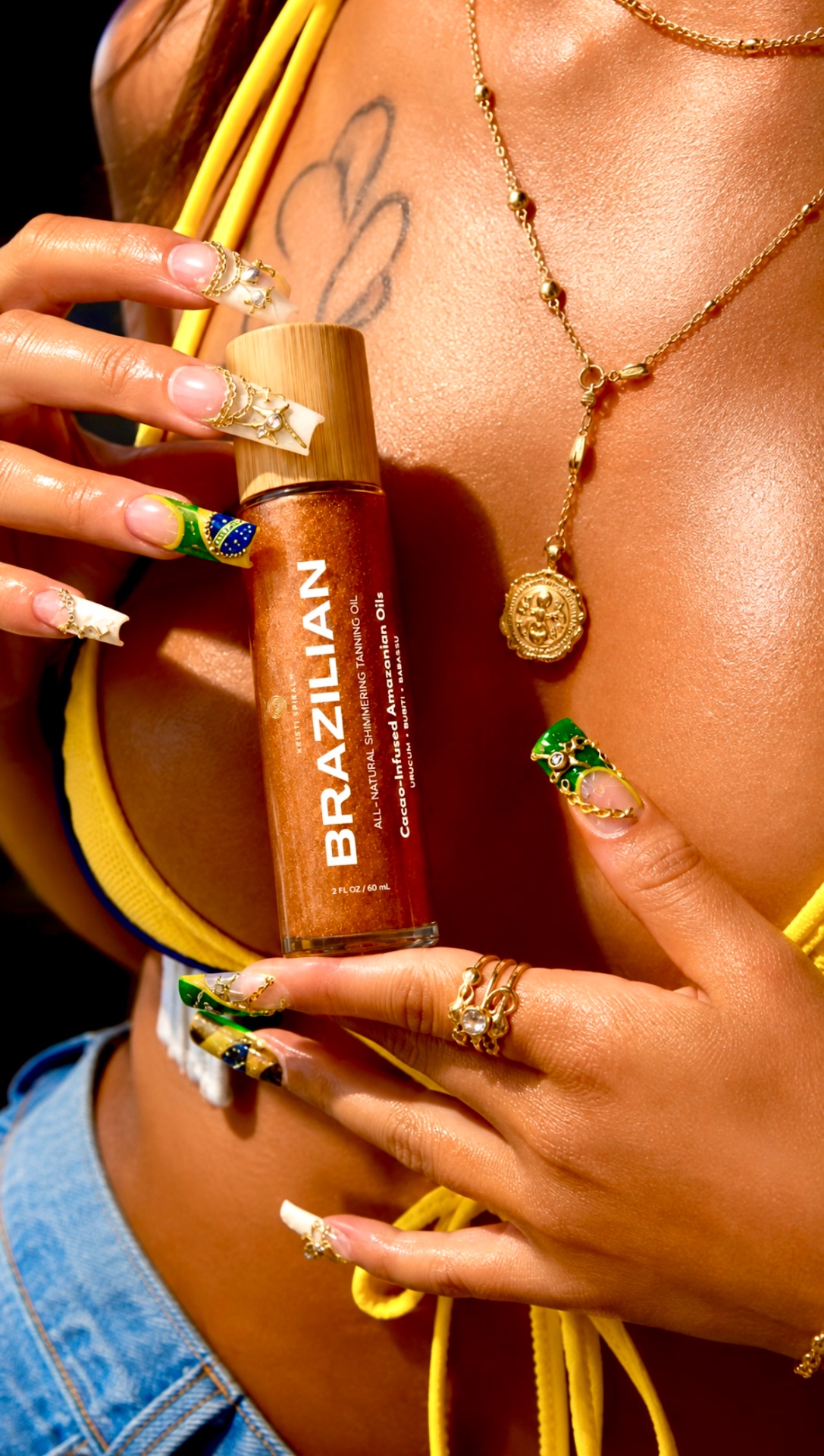 Hand holding Brazilian Tanning Oil with gold jewellery